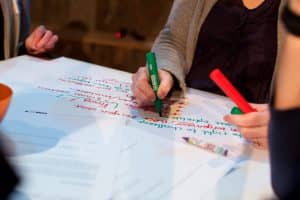 Mensen schrijven op papieren vellen met stiften