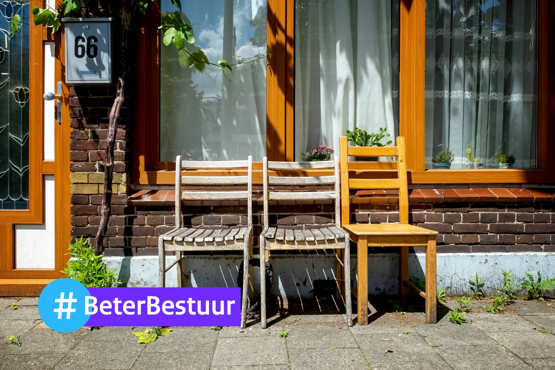 Voor een huis staan drie houten stoelen. Linksonderin staat #beterbestuur