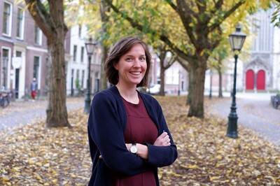 Een foto van Ruth Dijkstra die in een straat staat met allerlei bomen.