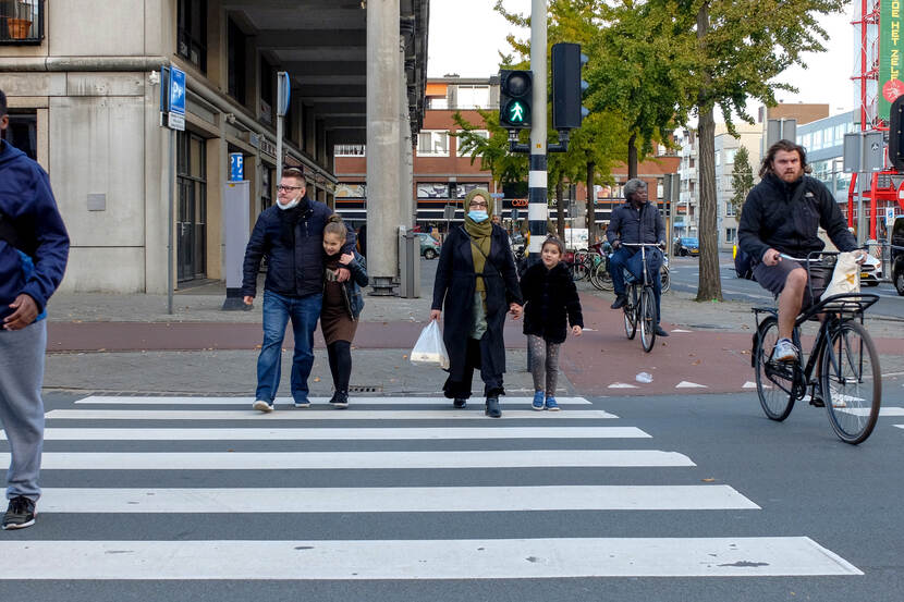 Mensen op straat met mondkapjes op