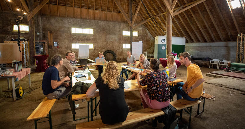 Tien mensen van het burgerpanel overleggen aan een tafels