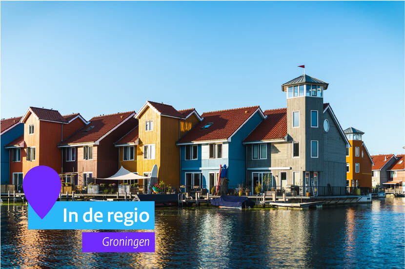 Gekleurde huisjes aan het water. Links onderin staat het icoon van In de regio met vermelding van groningen
