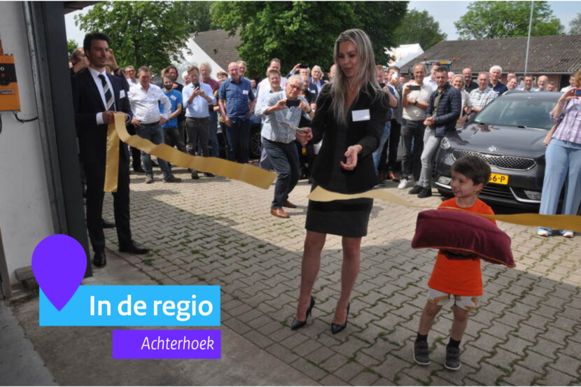 Een vrouw knipt een lintje door bij de opening van de meelwormboerderij Winsect.