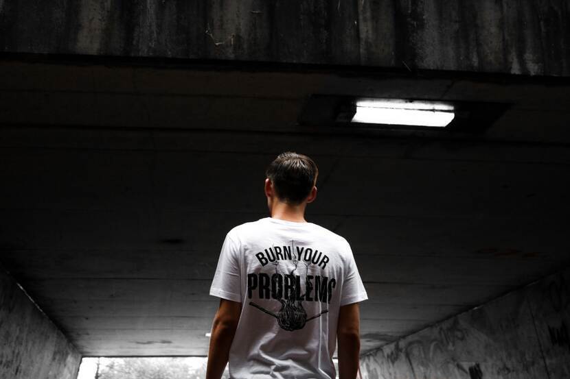 Shot van achter van T-shirt met tekst 'Burn your problems'