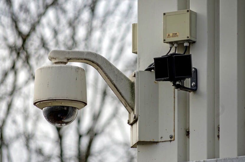 Een straatcamera hang aan een muur