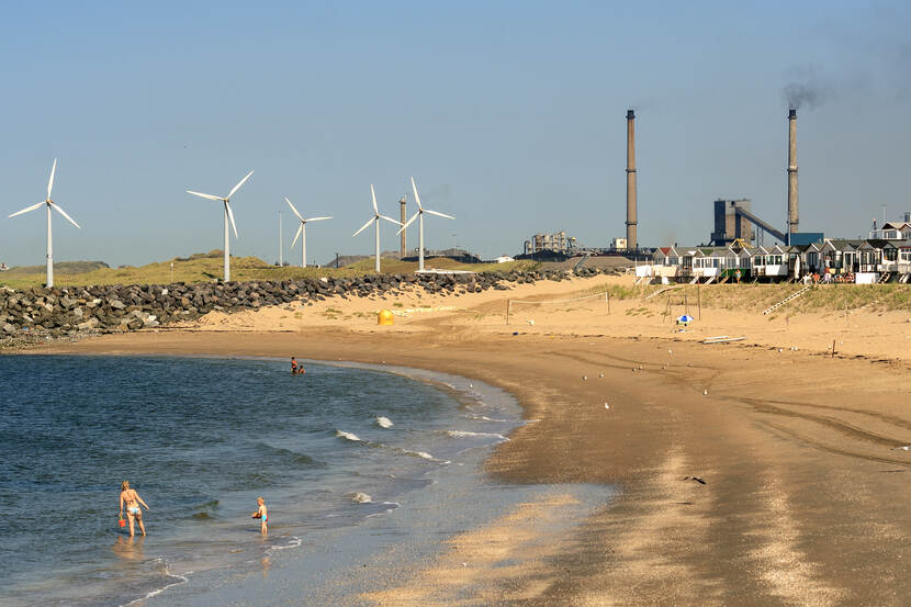 Kustlijn met recreatiestrand, met industrie op de achtergrond