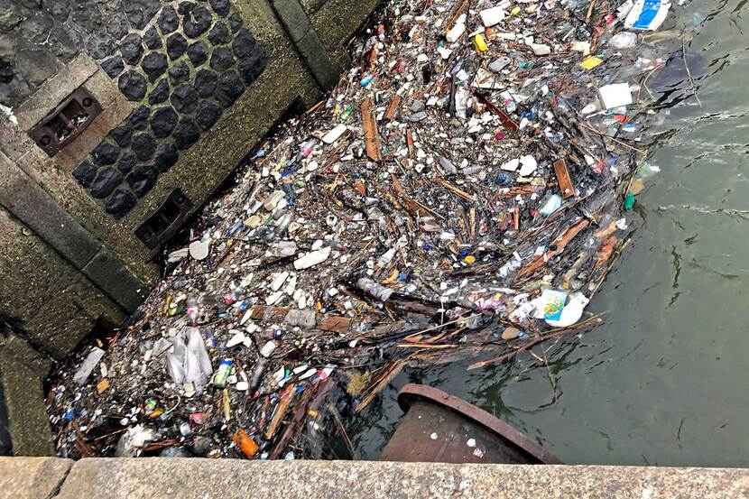 Plastic afval drijft in een sloot