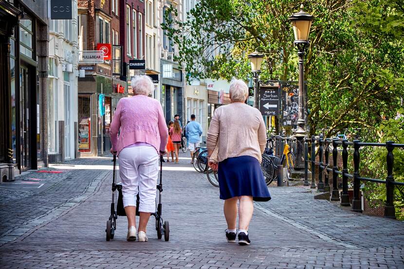 Twee oude vrouwen met rollator, rugaanzicht