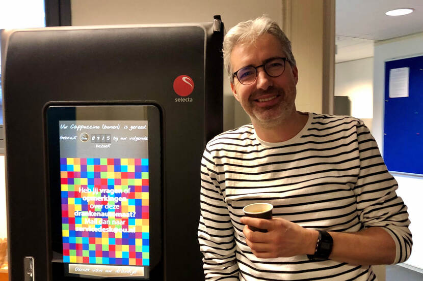 Mario Kieft naast een koffieautomaat