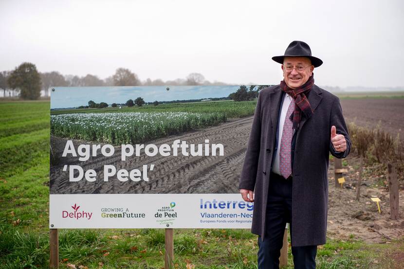 Pierre Bos bij een bord met de tekst agro proeftuin 'de peel'
