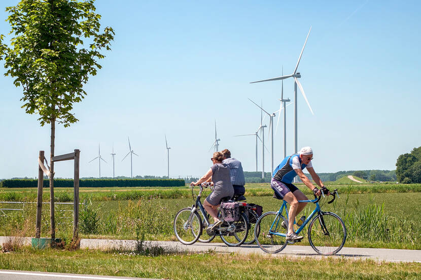 Fietsers met windmolens in de achtergrond