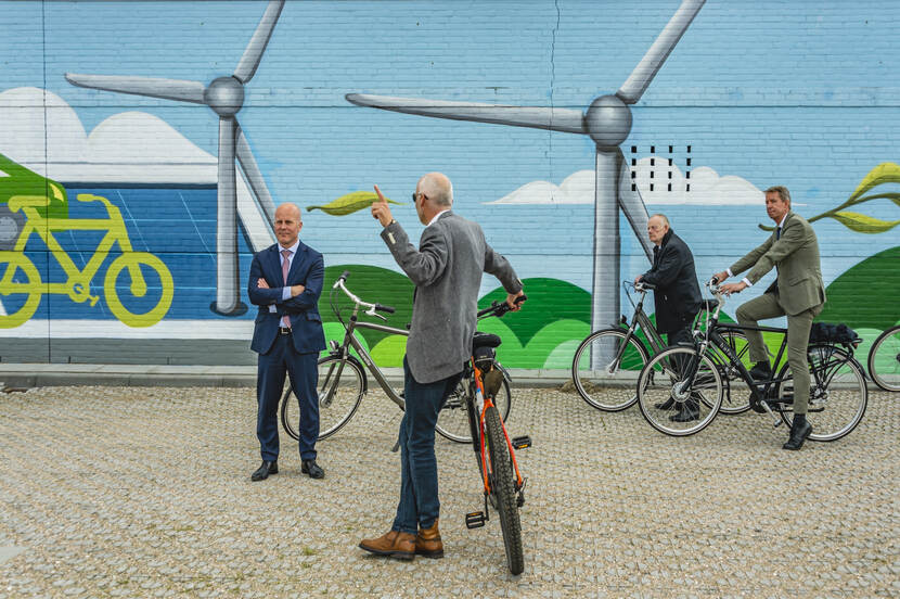 vier mannen voor streetart van windmolens