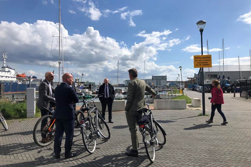 projectleider Jan Roest, staatsecretaris Raymond Knops, gedeputeerde Dick van der Velde en wethouder Albert Vader op de fiets bij de haven