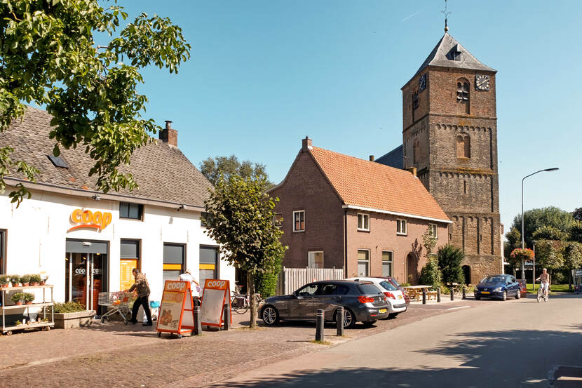 straatbeeld van een dorp met een supermarkt en een kerk