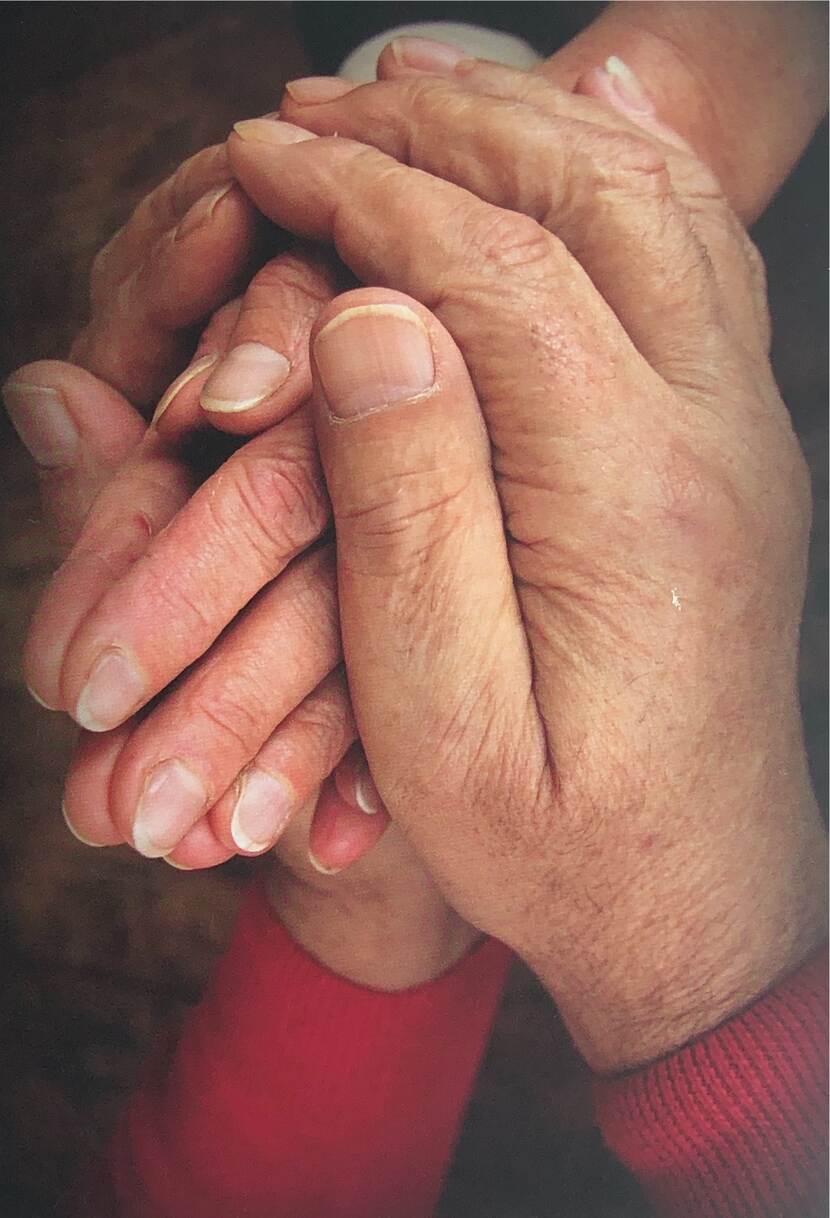 Foto van een persoon die de hand van een ander vasthoudt