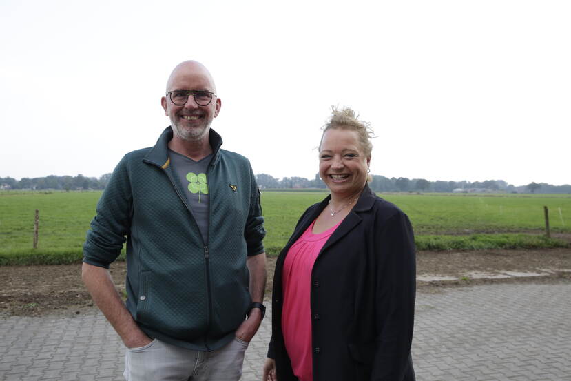 Een foto van Onno van Eijck die met zijn handen in zijn zakken naast Heleen Lansink staat. Ze staan voor een weiland, op een boerenerf.