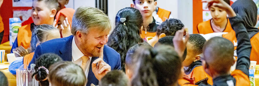 De koning aan tafel met allerlei kinderen