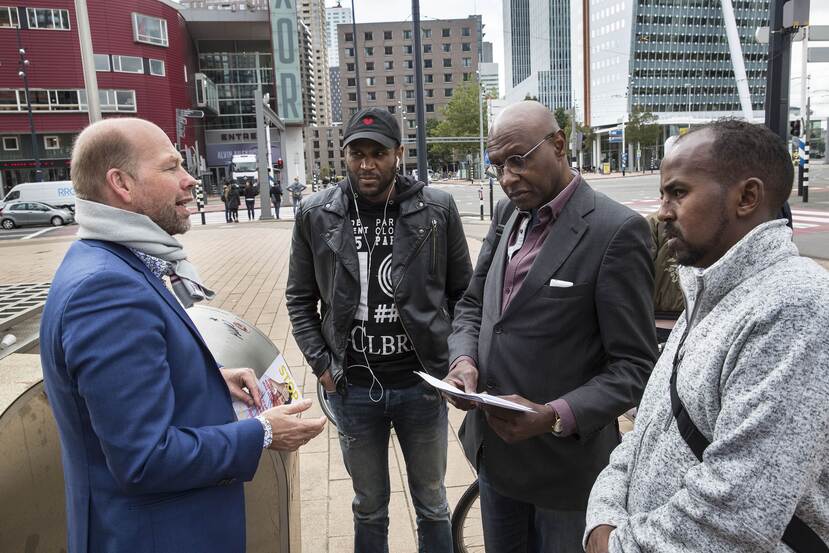 Postbode en columnist Ahmed Abdillahi laat de Rotterdamse wethouder Michiel Grauss van Armoedebestrijding kennismaken met stadgenoten