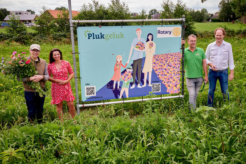 Mensen naast het bord van een Plukgelukveld