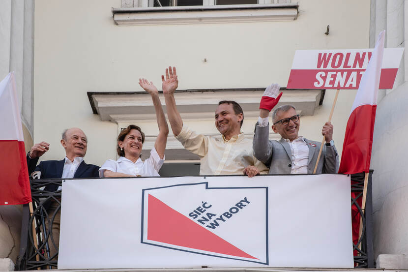 Anne Applebaum en haar man Radek Sidorski zwaaien op 5 juni 2023 vanaf hun balkon naar de deelnemers aan de nationale demonstratie voor democratische waarden in Warschau, Polen