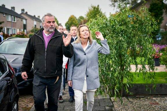 Minister Kajsa Ollongren bezoekt de proeftuin Lariks West in Assen en maakt daar een wandeling met buurtwerker Arthur Doornebosch.