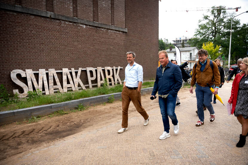 Mensen lopen langs een gebouw waar groot SMAAKPARK opstaat