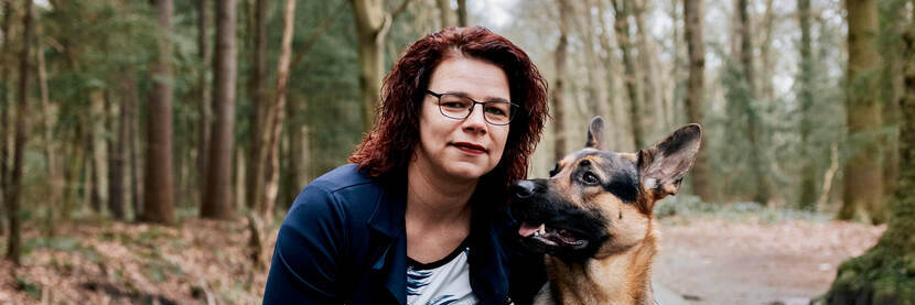 Jennie Boer met haar Duitse herdershond. Jennie heeft bruin haar, een bril en een witte huidskleur.