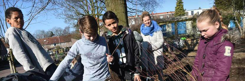 Een groep kinderen planten bomen in de grond