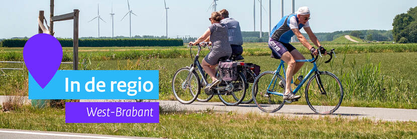 Drie fietsende mensen door de Brabantse polder. Op de achtergrond zijn windmolens zichtbaar