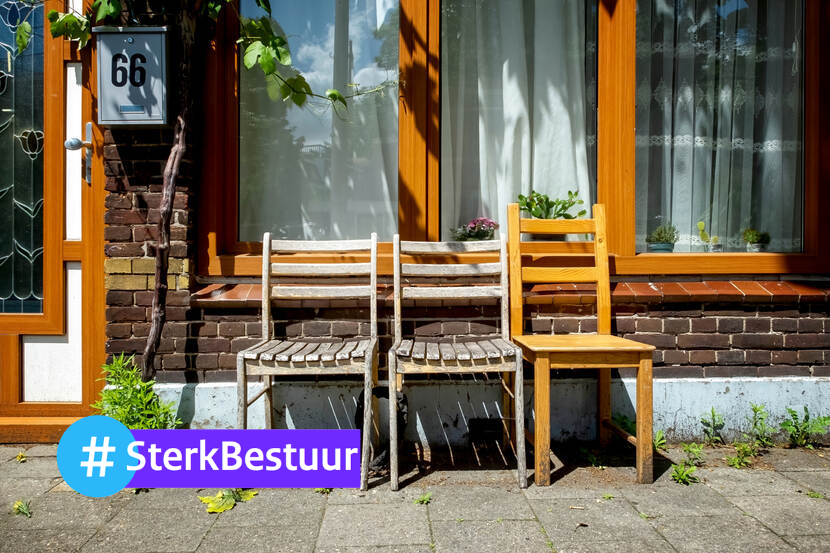 Voor een huis staan drie houten stoelen. Links onderin staat #sterkbestuur